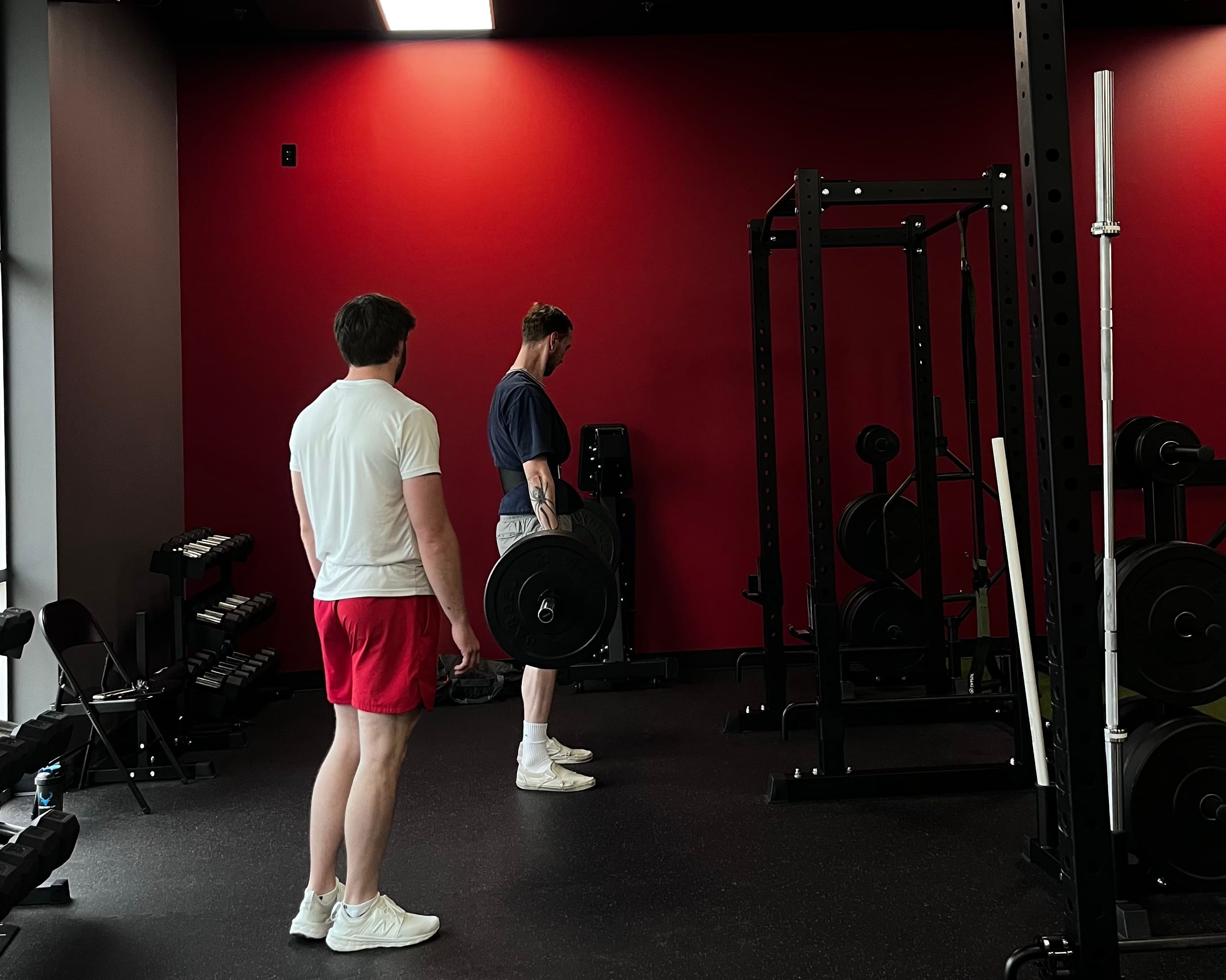 Trainer watching client deadlift