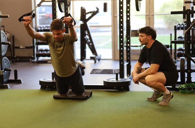 Coach Anthony coaching client on TRX